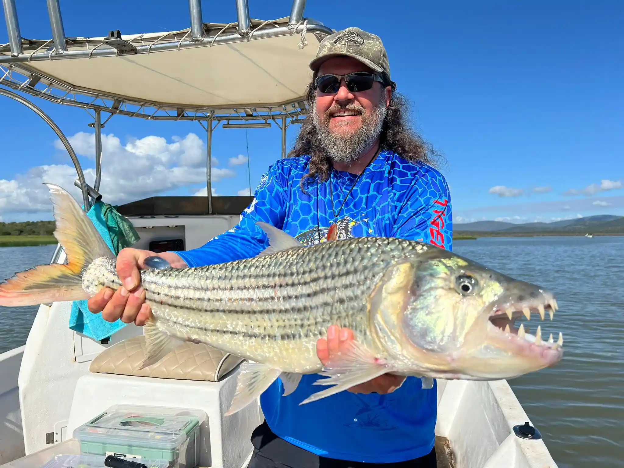 Guest holding a tiger fish on a Lake Jozini fishing boat